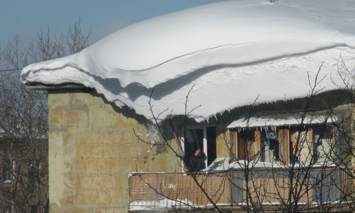 Босоногий мужчина примёрз к крыше дома на Котовского