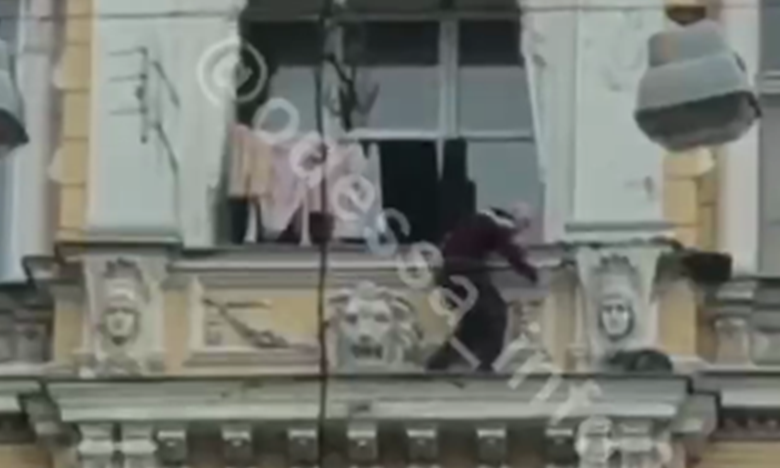 В центре Одессы мужчина  вылез на карниз дома, чтобы спасти кота (видео)